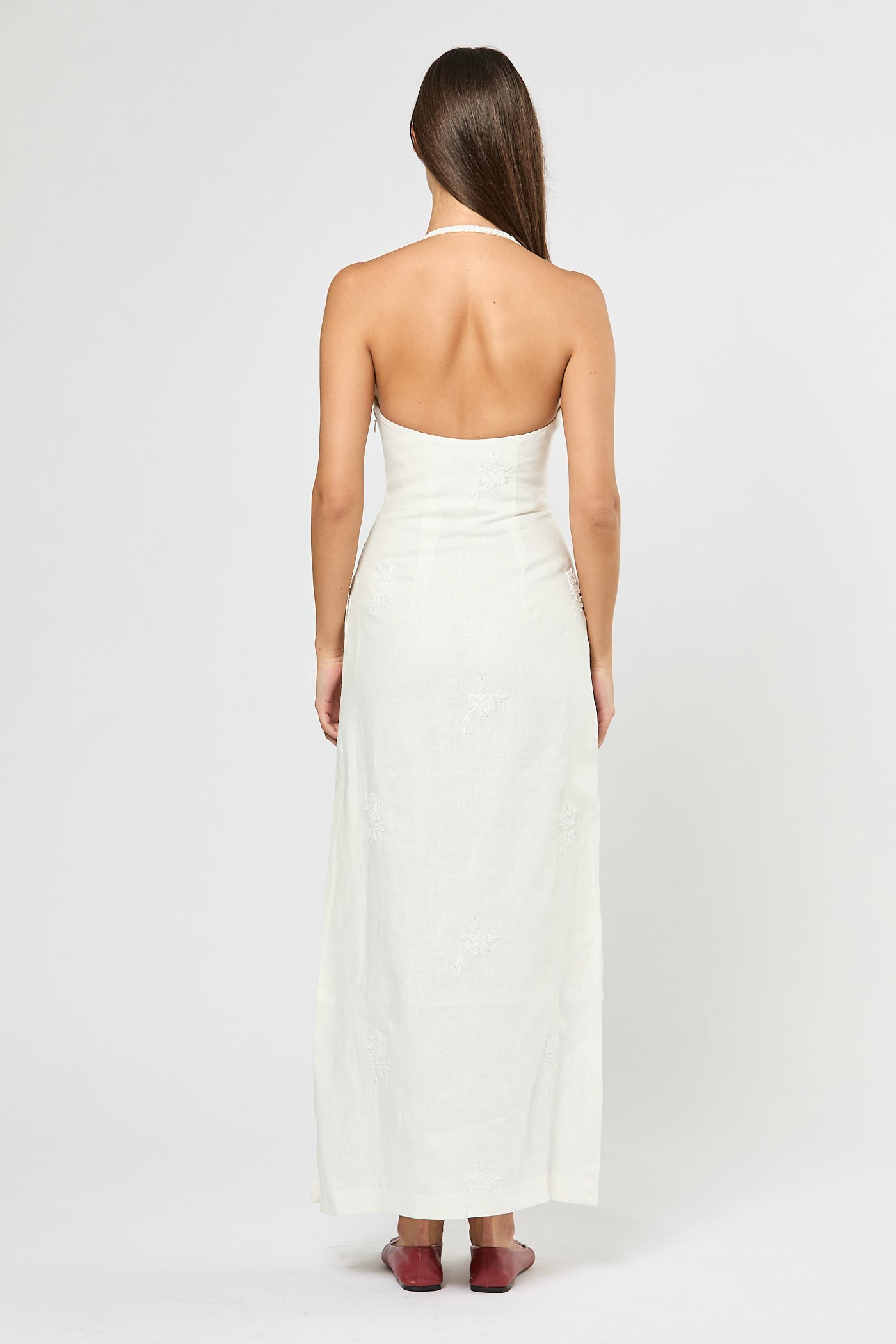 Woman wearing a white strapless dress on a plain background