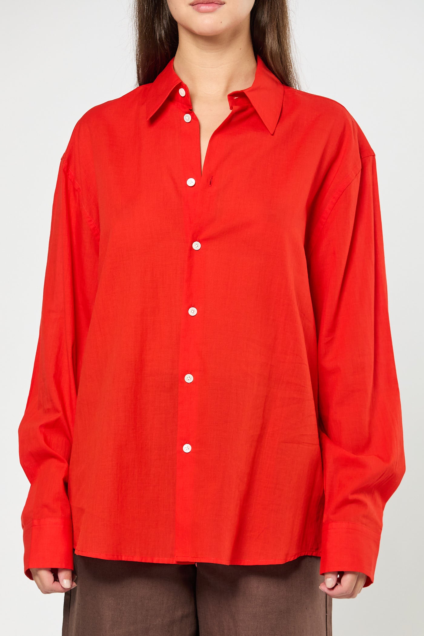Red button-up shirt worn by a person on a white background