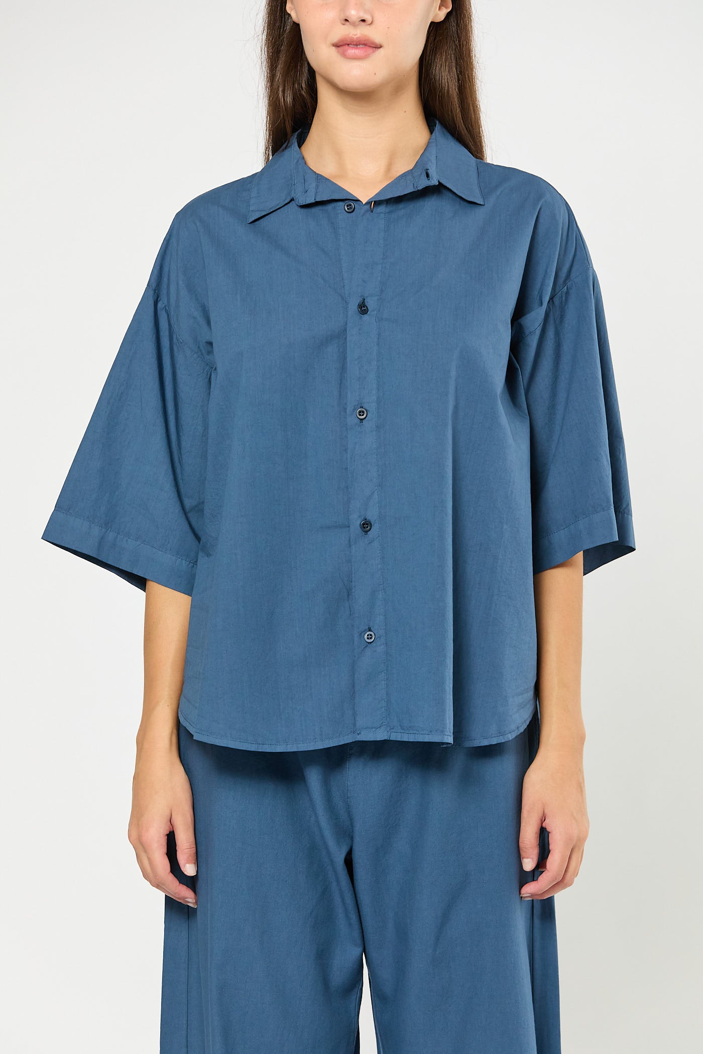 Person wearing a blue outfit with a plain background