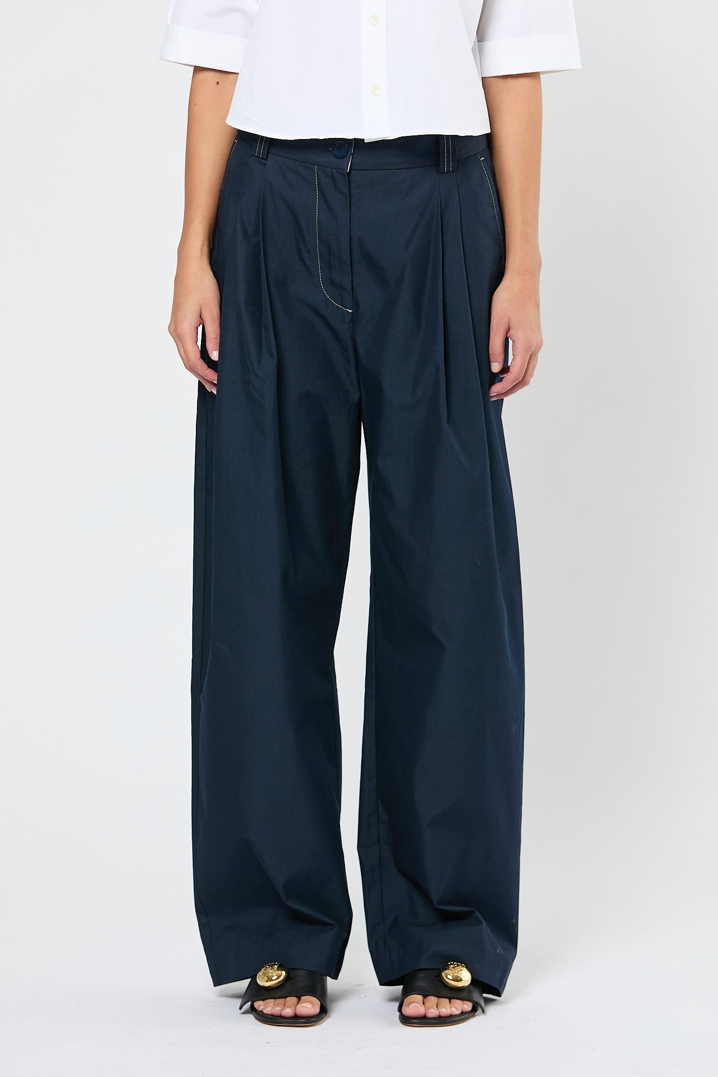 Person wearing navy wide-leg pants on a white background