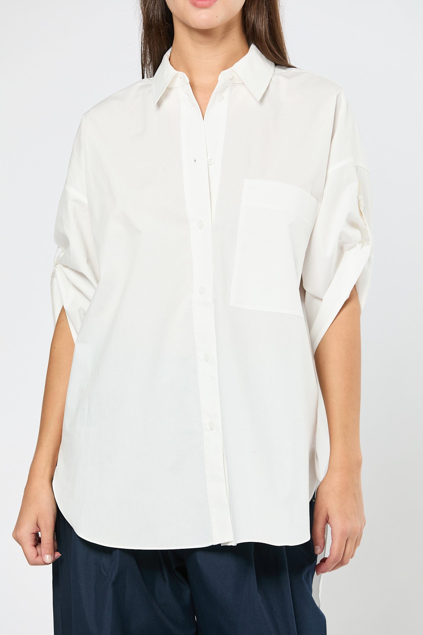 Person wearing a white shirt on a plain background