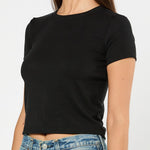 Person wearing a black t-shirt and blue jeans on a white background