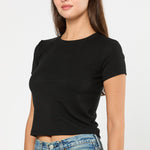 Woman wearing a black t-shirt and blue jeans on a white background