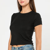 Woman wearing a black t-shirt and blue jeans on a white background