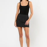 Woman wearing a black tank top and black skirt on a white background